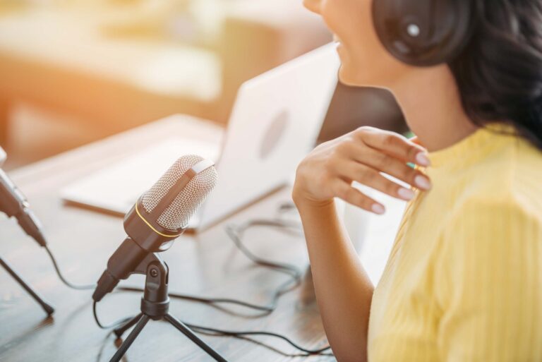 cropped-view-of-smiling-radio-host-sitting-near-mi-JFMPVQQ