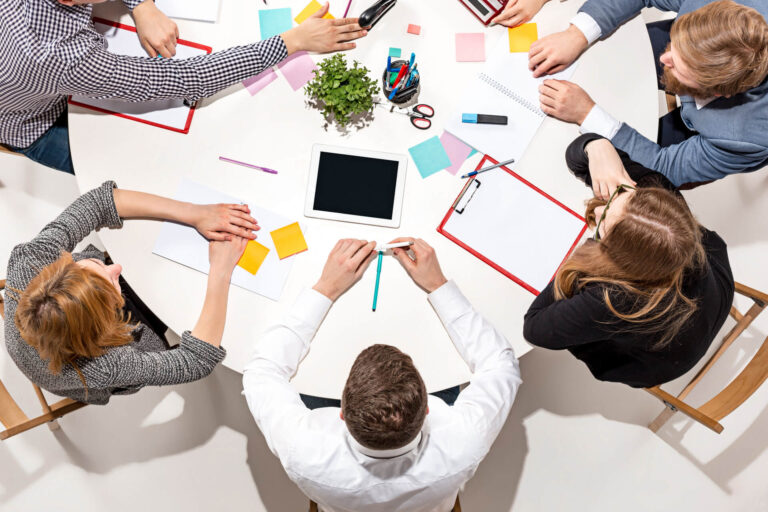 team-sitting-desk-checking-reports-talking-top-view (1)